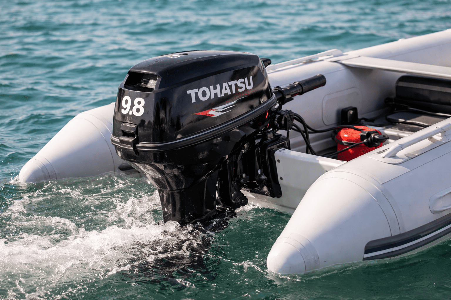 Tohatsu MFS series portable 4-stroke outboard motor on small dinghy — shop Tohatsu portable outboards at Boat Engine LLC New York